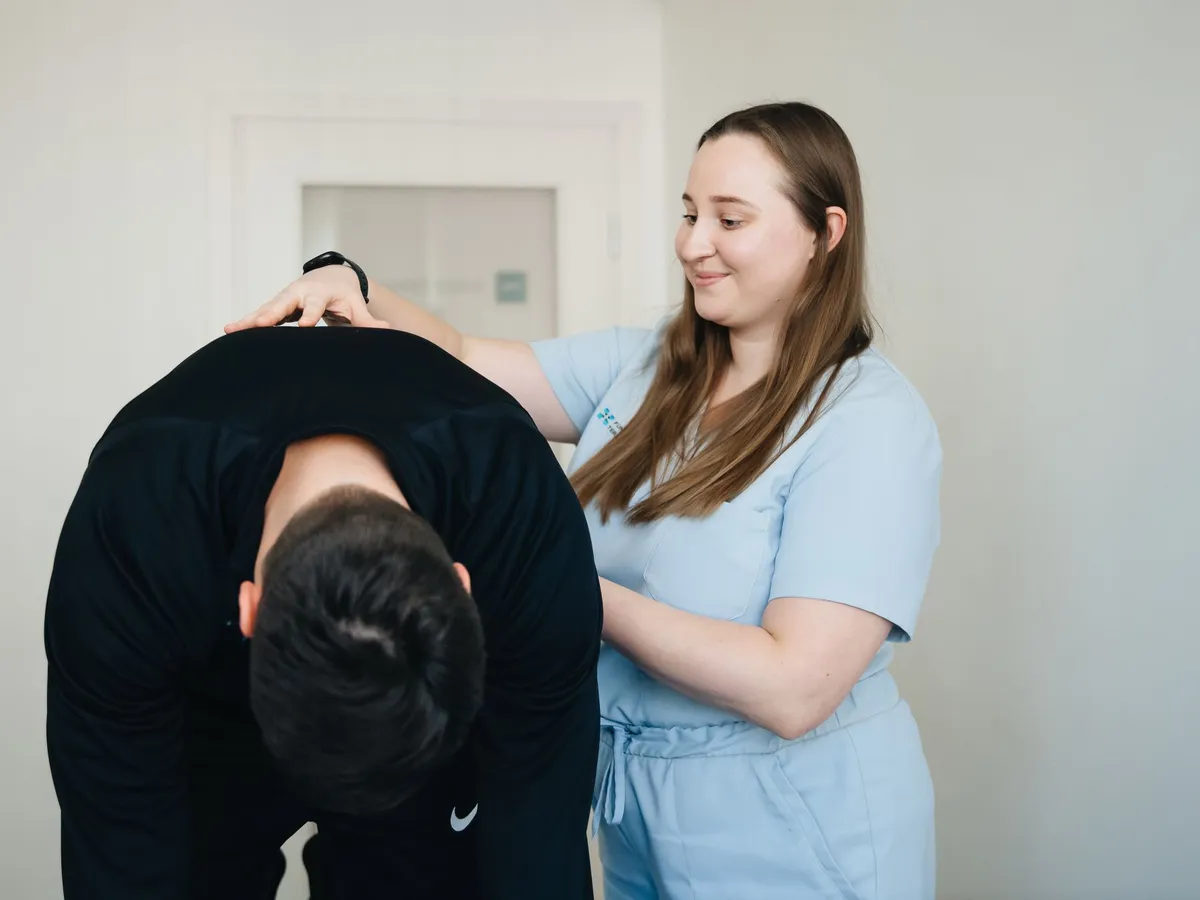 Physiotherapeut begleitet eine Patientin bei der Behandlung
